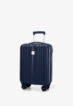 Námořnický tvrdý kufr s vertikálními drážkami, čtyřmi koly, výsuvnou rukojetí a stříbrnou logem. Má odolné zipy a akcenty.