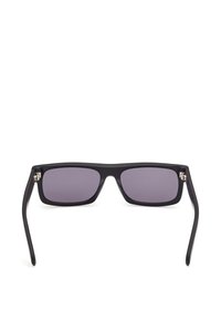 Lunettes de soleil rectangulaires noires avec des verres teintés foncés et des branches légèrement courbées, vues de face sur un fond blanc.