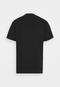 Camiseta de algodón negra de manga corta. Presenta un cuello redondo y una textura lisa y sencilla, diseñada para un ajuste estándar.