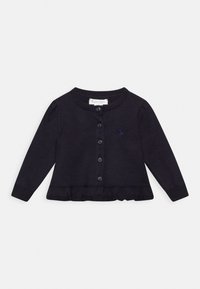 Mörk marinblå stickad cardigan med långa ärmar, ribbade avslut, volangkant och knappstängning. Har en liten logotyp på bröstet.