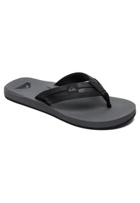 Sandal de tip flip-flop negru cu talpă texturată pentru aderență, curea ajustabilă și accent cu logo. Design plat dintr-un material ușor, potrivit pentru purta casual.