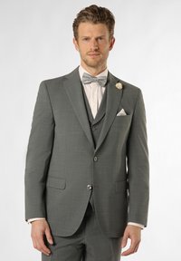 Grauer Dreiteiler mit subtiler Textur, passender Fliege mit Pünktchen, weißem Hemd und weißem Einstecktuch. Blumenakzent auf dem Revers.