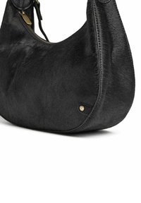 Černá kožená kabelka s měkkým, strukturovaným povrchem, zakřiveným tvarem a mosazným detailem. Má zipové zapínání a pohodlný popruh.