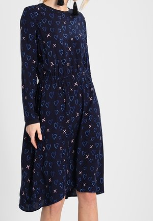 Marineblaues Langarmkleid mit elastischem Bund, verziert mit einem Herzen und einem 'X'-Muster in Hellrosa und Blau. Glatte Stoffstruktur.