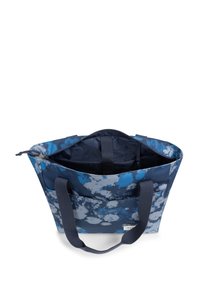 Sac fourre-tout bleu marine avec un motif bleu en forme de nuage, doté de poignées en tissu double et d'une fermeture éclair. L'intérieur comprend plusieurs compartiments.