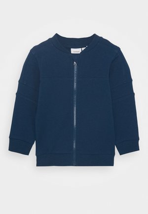 Veste longue à manches longues bleu marine pour tout-petit, avec fermeture éclair à l'avant, poignets côtelés et col rond sur fond blanc.