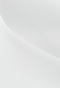 Tela blanca lisa con una sutil luz y sombra que crea una línea curva suave a lo largo de la superficie.