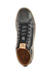 Black leather high-top shoe with lace-up and side zipper closure. Features brown interior and tan branding on the tongue. Rubber sole.