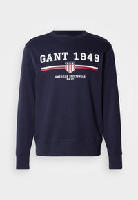 Navy blauwe sweatshirt van katoen, met een ronde hals. Gedrukte logo "GANT 1949" met schild en strepen in rood en wit.