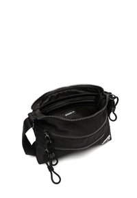 Czarna torebka na ramię z materiału, z dwoma zamykanymi na zamek komorami, regulowanym paskiem i teksturowanym wykończeniem. Widoczna wewnętrzna metka, minimalistyczny design.