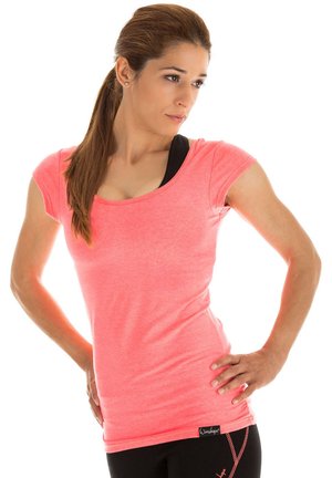 Short-sleeved, scoop-neck athletic top in bright pink fabric. Features a fitted silhouette and is paired with black leggings displaying a side pattern.