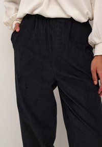 Corduroy broek in donker marineblauw met verticale strepen, met een ontspannen pasvorm, zijzakken en een elastische tailleband voor comfort.