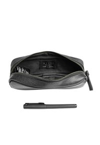 Crna kožna torbica s patentnim zatvaračem otvorena da pokaže unutarnju etiketu, s crnom olovkom postavljenom ispod na bijeloj pozadini.