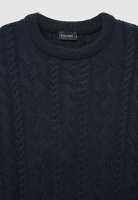 Dunkel marineblauer Strickpullover mit Rundhalsausschnitt, gerippten Ärmelbündchen und strukturiertem Muster. Das Etikett trägt die Aufschrift "CALLIOPE" in Größe L.