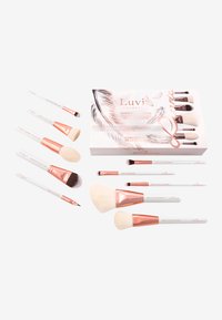 Set of makeup brushes featuring white handles with rose gold accents. Includes various shapes and sizes. Packaged in a decorative box.