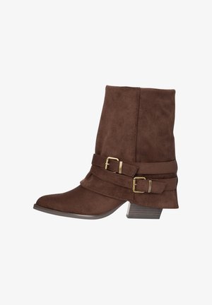 Bottine en daim brun avec un petit talon empilé, un bout pointu et deux sangles décoratives à boucle dorée sur le côté.