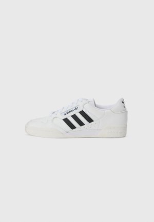 Hvide lædersneakers med tre sorte striber, struktureret overdel, rund tå og en gummisål med logo accenter på hælen.
