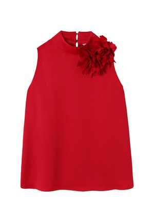 Robe rouge sans manches avec un col haut et une grande fleur en tissu embellissant l'épaule droite, présentée sur un fond blanc.