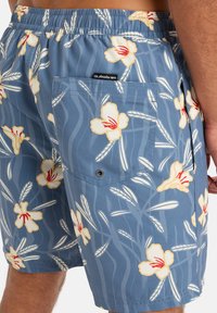 Modré plavky s kvetinovým vzorom, ktorý obsahuje žlté a červené kvety. Súčasťou je aj zadná kapsa so šnúrkou.