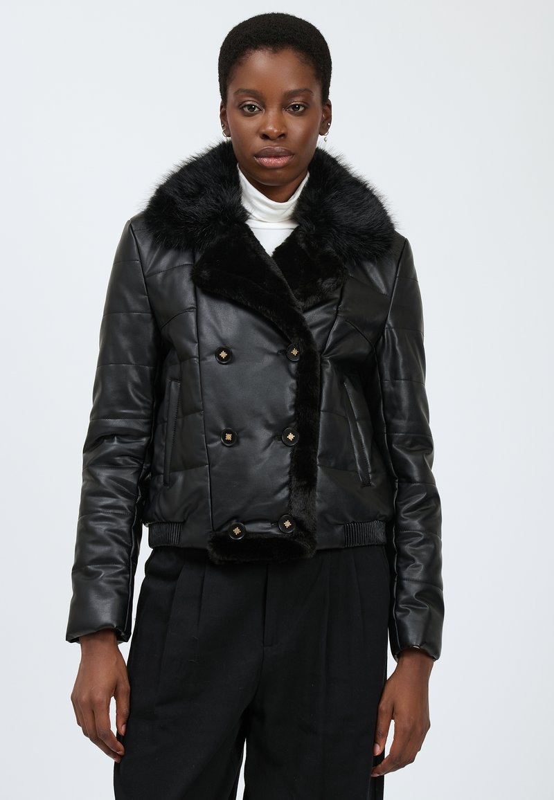 Veste en cuir noir courte avec un col en fausse fourrure, présentant un design à double boutonnage et des accents de boutons dorés. Texture lisse et détails matelassés.