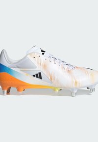 Botas de fútbol blancas con suela degradada de azul a naranja, parte superior texturizada, acentos de logotipo en negro y cinco tacos para tracción.