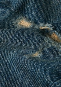 Jeans tkanina temno modre barve, ki vsebuje razbarvane modele in lažje obrabe, kar ustvarja teksturiran videz z vidnimi nitmi.
