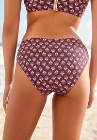 Vysoké bikiny s nohavičkami v bohatých burgundských farbách s bielym a ružovým kvetinovým vzorom. Hladký povrch so zakrivenými švami a bočným prekrytím.