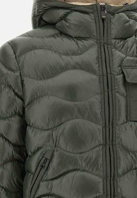 Giacca imbottita verde scuro con motivo trapuntato, caratterizzata da collo alto, zip frontale e tasche laterali. Tessuto liscio e leggero.