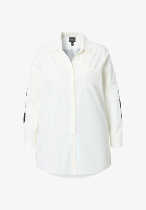 Biała koszula z długim rękawem, z kieszenią na piersi i czarnym wzorem kropek na rękawach. Wykonana z lekkiego materiału.