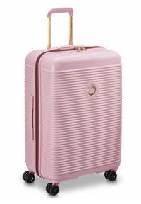 Valigia rigida rosa con texture a righe verticali, dettagli dorati, doppie ruote, manico telescopico e chiusura a zip.