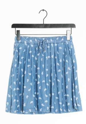 Niebieska spódnica z białym wzorem paisley, elastyczną talią ze sznurkiem, zawieszona na czarnym wieszaku na ubrania.