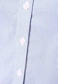 Blue and white striped fabric with button closure, featuring vertical lines and a smooth texture. Buttons are round and white.
