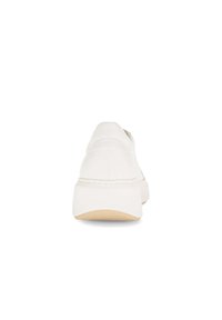 White leather sneaker with a solid design, rounded toe, elastic side panel, and a beige rubber sole. Back view shows minimal stitching detail.