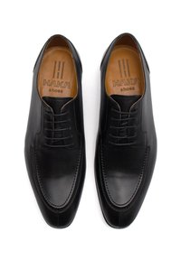 Scarpe da uomo in pelle nera con un design elegante, punta affusolata e cuciture a contrasto. Logo inciso visibile sulla soletta color marrone.