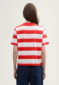 Red and white striped t-shirt with short sleeves, round neckline, made of cotton, featuring horizontal lines of varying thickness.