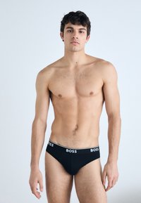 Sorte bomuldsboxershorts med BOSS-logo på linningen. Pasformen er tætsiddende med en glat tekstur og et minimalistisk design, uden mønstre eller accenter.