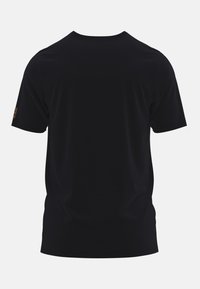 Camiseta de manga corta negra hecha de una tela suave; presenta un escote redondo y un diseño minimalista; incluye un pequeño detalle de logotipo en la manga.