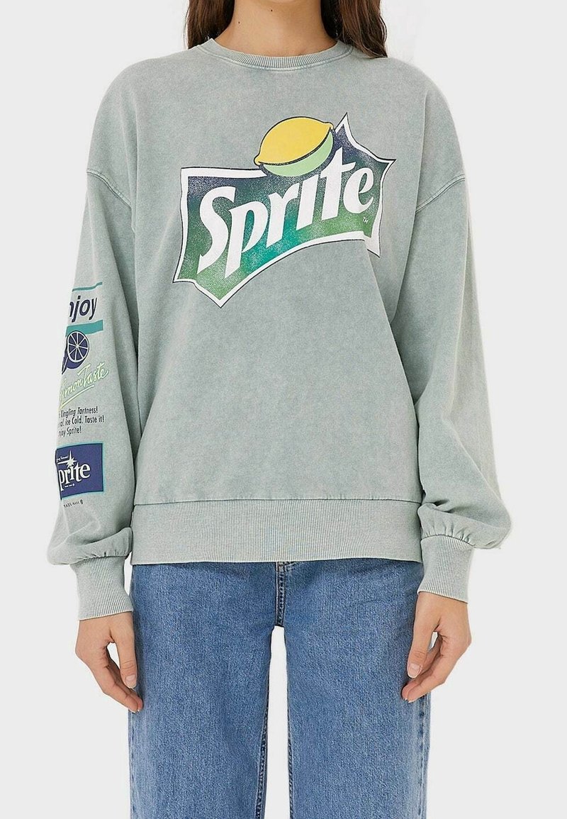 Felpa verde menta con un grande logo Sprite, caratterizzata da maniche a sbuffo, polsini a coste e dettagli testuali su entrambe le maniche.