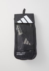 Sac en mesh noir avec rabat. Présente un logo Adidas blanc et le texte "Gants de gardien de but Football/Soccer Copa" à l'avant. Fenêtre transparente.