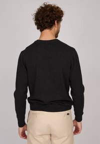 Pull en laine gris foncé avec un col rond, des manches longues et des poignets côtelés. Texture douce, coupe classique et peu de détails de design à l'arrière.