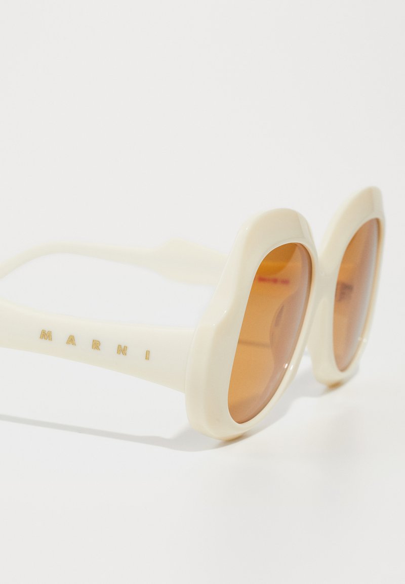 Witte oversized zonnebril met bruin getinte lenzen, voorzien van een glad plastic montuur en de merknaam "MARNI" in het goud aan de zijkant.