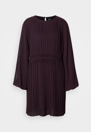 Plommefarget kjole med lange plisserte ermer, en tettsittende bodice og smocket midje. Har rund hals og nøkkelhullåpning bak.