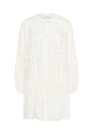 Vit bomullsblus med knapp-up framtill, rund halsringning och puffärmar. Har utskurna bladmönster och en rynkad midja.