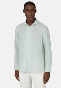 Camicia a maniche lunghe verde chiaro con colletto abbottonato, realizzata in un tessuto testurizzato. Presenta un orlo dritto e polsini con un solo bottone.
