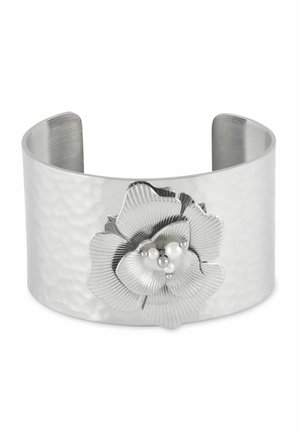 Large bracelet manchette en argent avec texture martelée, ornée d'une grande fleur en argent avec de petites perles blanches au centre.