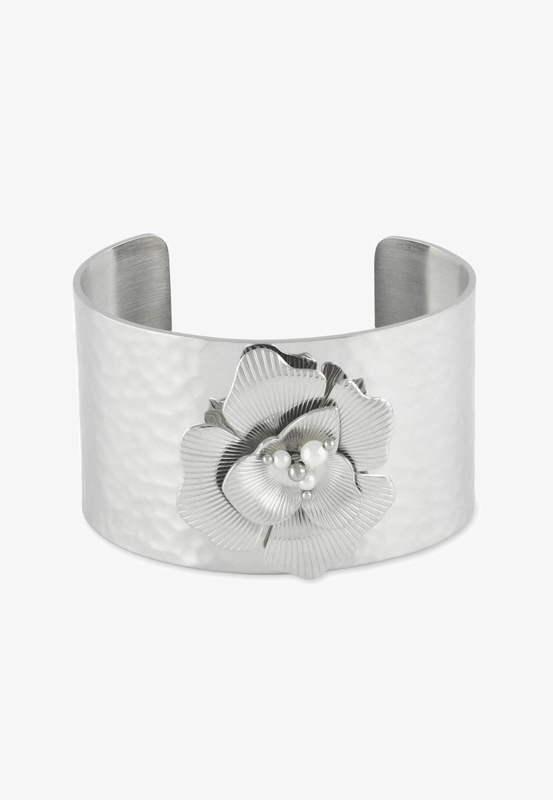 Široký stříbrný náramek s texturou kladívkování, zdobený velkou stříbrnou květinovou ozdobou s malými bílými perlami uprostřed.
