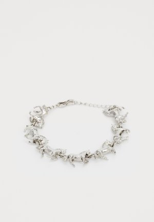 Ezüst karkötő, amely bonyolultan kidolgozott, mozgó lófigurákat tartalmaz, finom lánccal összekapcsolva és kapoccsal rögzítve.