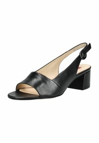 Sandale en cuir noir à talons ouverts, avec une large sangle sur le devant et un talon blocs. Elle dispose d'une fermeture à bouton rond sur la sangle de la cheville.