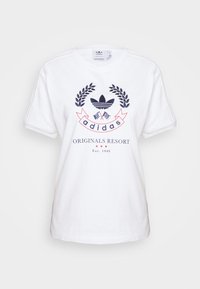 Witte katoenen t-shirt met een ronde halslijn, korte mouwen en een centraal navy en rood grafisch ontwerp met "adidas" en laurierpatronen.