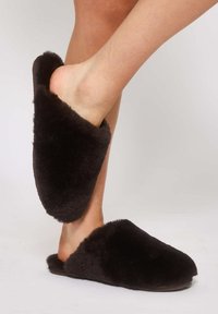 Sorte pelsforede slippers med slip-on design, der har en blød tekstur og rund tå. Sålens flade design sikrer komfort og stabilitet.